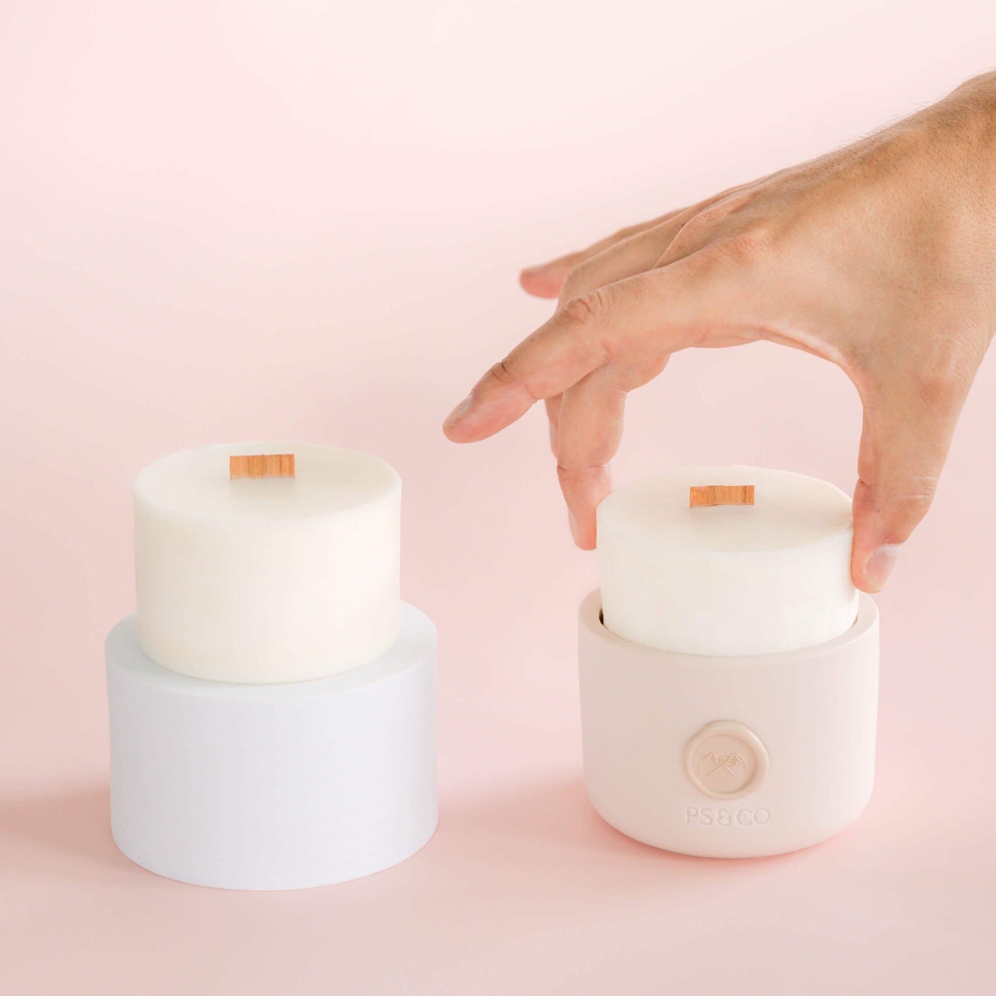 A wax refill being placed into a new vessel next to another standalone wax refill.